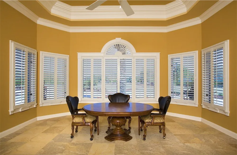 Beautiful dining room with large plantation shutters installed on the windows